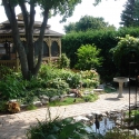 wooden 10 by 16 foot oval gazebo surrounded by lush gardens